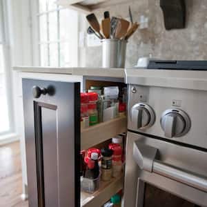 A kitchen stove with a pull-out drawer for spices